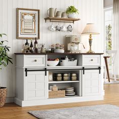 a kitchen with white cupboards and shelves filled with dishes on top of wooden floors