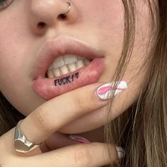 a close up of a person with tattoos on her mouth and fingernails,