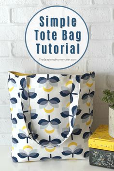 the simple tote bag is sitting next to some books and a potted plant