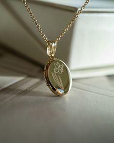 PHOTOS: No inserts, the photos are glued on. Please message us your photos after you place your order! ADDITIONAL ENGRAVING: Add this to your order: https://etsy.me/3CTK74W METAL/MATERIAL: 14K Gold Filled / Sterling Silver / 14K Yellow Solid Gold The metal material are stamped on the back of the locket. LOCKET DIMENSIONS: Locket Size - 19mm x 10mm (small) including the bail. Please check sizing before ordering. CHAIN: Sturdy 1mm smooth chain. The chain material matches the material of the locket Elegant Locket Necklace With Flower Charm As Gift, Elegant Flower Charm Locket Necklace For Anniversary, Elegant Round Pendant Locket Necklace With Birth Flower, Elegant Flower Pendant Locket Necklace For Keepsakes, Elegant Round Locket Necklace With Birth Flower, Elegant Birth Flower Round Pendant Locket Necklace, Elegant Locket Necklace For Mother's Day Memorial, Classic Birth Flower Jewelry As Gift, Classic Birth Flower Jewelry For Gift