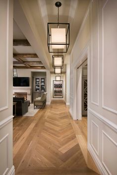 an empty hallway with wood flooring and white trim on the walls is pictured in this image