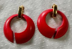 From the late 60's or early 70's, these big and bold red earrings from Trifari are just fabulous. Large red wooden rounds have a mid mod style and they hang from large gold tone clip on settings. The pair was well loved and cared for, but they do show minor signs of wear, commiserate with age. The gold tone finishes on the clips have not faded at all, and the red is an apple-y shade. Very versatile, now and through all the seasons. The large clip ons hold the red discs freely and can actually be Vintage Red Pierced Earrings, Retro Red Clip-on Earrings For Formal Occasions, Red Retro Round Earrings, Retro Red Round Earrings, Vintage Red Clip-on Earrings For Evening, Vintage Red Brass Earrings, Wooden Rounds, Vintage Trifari Earrings, Vintage Multicolor Drop Clip-on Earrings