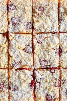 several squares of food that are covered in powdered sugar and cranberry sauce