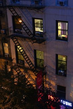 an apartment building at night with stairs leading up to the windows