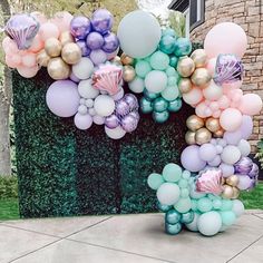 the balloon arch is decorated with pastel colors