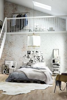 a bedroom with white brick walls and wooden floors