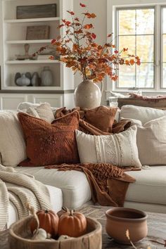 a living room filled with white couches and pillows on top of a wooden table