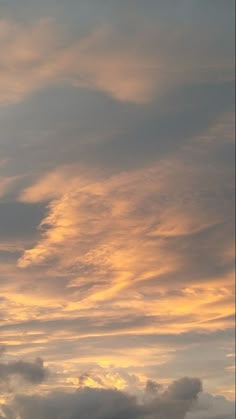 an airplane is flying in the sky at sunset or dawn with some clouds behind it