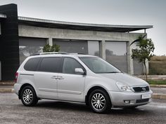 a white minivan parked in front of a building