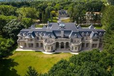 an aerial view of a large mansion in the middle of some trees and grass area