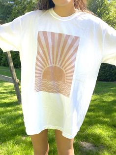 "The PERFECT summer graphic tee! Comfort Colors white t-shirt with a sun design. Model is 5'4\" and wearing a size XL for an oversized look. 100% cotton." Summer Cotton T-shirt With Graphic Design, White Graphic Design Top For Summer, White Graphic Design Tops For Summer, White Summer Top With Graphic Design, White Print Graphic Design Summer Tops, Summer Tops With White Graphic Design, Summer White Print Tops With Graphic Design, Summer White Print Graphic Tops, Summer Graphic Design White Print Tops