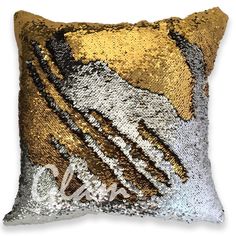 a gold and silver sequinized pillow with the word love on it's side