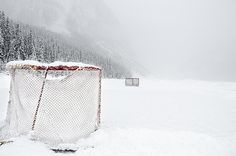 an ice hockey goal in the middle of a snowy field