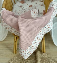 a baby's crib with a pink blanket on it