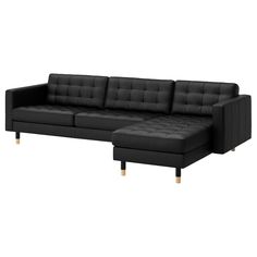 a black leather couch with wooden legs and a chaise lounge in front of it