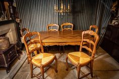 a dining room table with six chairs and a fire place in the corner next to it