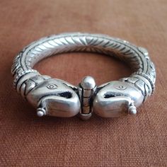 Elephant headed silver bracelet from North India.Wonderful 92.5 silver piece.Traditional Rajastani bracelet. Total Diameter: 8.7 centimeters Inner diameter: 6.3 centimeters Weight:105 grams Shipping: certified Post Office Mail with track number. Thanks for your visit! Silver Symbolic Bracelets For Ceremonial Use, Heavy Silver Bracelets For Ceremonial Occasions, Traditional Silver Sterling Silver Bracelet Hallmarked, Traditional Silver Sterling Hallmarked Bracelet, Traditional Hallmarked Silver Sterling Bracelet, Silver Temple Jewelry Bracelet For Gift, Silver Temple Jewelry Bracelets For Ceremonial Occasions, Ceremonial Silver Temple Jewelry Bracelet, Silver Bracelet With Oxidized Finish For Festivals