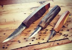 three different types of knives on a wooden table