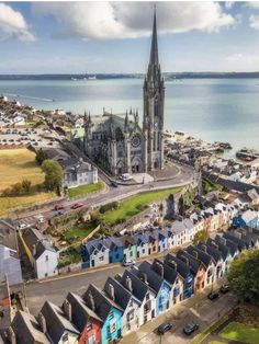 an aerial view of a city with many colorful houses in front of the water and a church