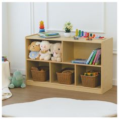 a wooden shelf filled with stuffed animals next to a white rug and bookshelf