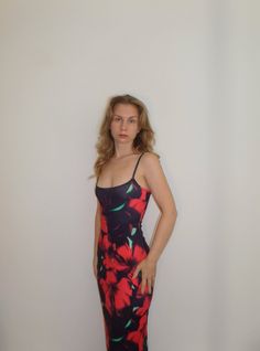 This black and red hibiscus maxi dress is perfect for those who love a 90s model vibe. The dress is designed to hug your curves and show off your shape in a figure hugging body con style. The dress features strappy detailing with a scoop neckline, adding an extra touch of femininity. It's perfect for any special occasion, whether it's a holiday, beach day or birthday celebration. The tropical Hawaiian hibiscus print adds an exotic touch to the dark feminine style of the dress. With its stretchy Fitted Summer Maxi Dress For Night Out, Fitted Sleeveless Maxi Dress With Tropical Print, Fitted Red Floral Print Bodycon Dress, Flirty Fitted Summer Maxi Dress, Fitted Flirty Summer Maxi Dress, Flirty Fitted Maxi Dress For Summer, Red Fitted Bodycon Dress For Beach, Red Fitted Bodycon Beach Dress, Tropical Print Sundress Maxi Dress For Parties