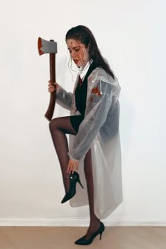 a woman dressed as a doctor with an ax in her hand and holding a hammer