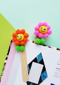 two popsicles decorated with flowers on top of a piece of paper