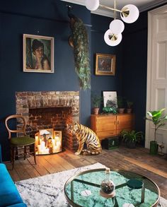 a living room filled with furniture and a fire place in front of a blue wall