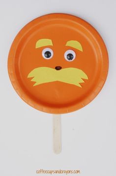 an orange paper plate with a face on it