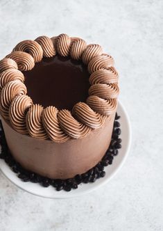 a chocolate cake sitting on top of a white plate next to coffee beans and a knife