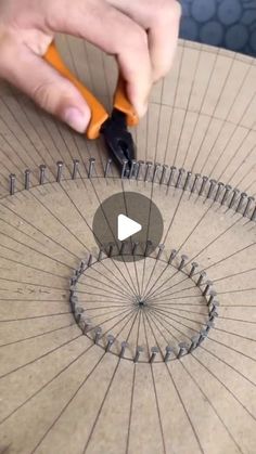 a person using scissors to cut circles on a piece of cardboard