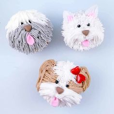 three small dogs made out of yarn on a white surface with one dog's head sticking out