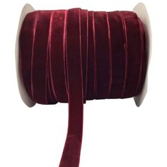 a roll of red velvet ribbon on a white background