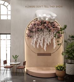 flowers are hanging from the ceiling in front of a display with white and pink flowers