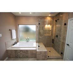 a bathroom with a walk in shower next to a bath tub