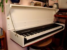 an old piano is chained to a shelf in a room with books and other items