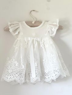 Beautiful and elegant baby girls' lace baptism dress. Two-piece set including a delicately embroidered cap-sleeve gown with matching lace bonnet. Complete with a linen and cotton blend liner, to ensure comfort. Feel free to add one of our adorable headbands to complete the look. White Lace Baby Dress, White Embroidered Baptism Dress, Lace Baptism Dress With Lace Patchwork, Fitted Lace Baptism Dress, Fitted Baptism Dress With Scalloped Lace, Lace Patchwork Baptism Dress For First Communion, Lace Baptism Dress With Ruffles And Short Sleeves, Elegant Embroidered Lace Baptism Dress, Spring Baptism Dress With Lace Work