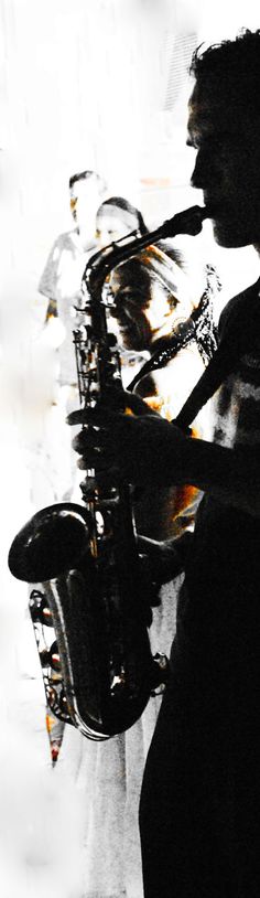 a man standing next to a saxophone in front of a window