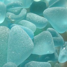 some blue and green glass pieces are on the ground together, as if they were floating or floating in water