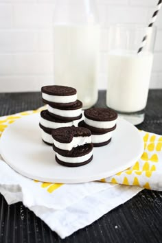 oreo sandwich cookies on a plate with milk in the backgroung and glass of milk