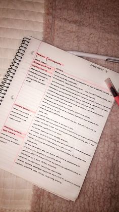 a notepad and pen sitting on top of a bed