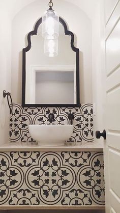 a white sink sitting under a bathroom mirror next to a wall mounted faucet