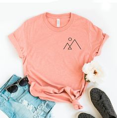 "Minimalist Mountain T-shirt, Aesthetic Shirt, Mountain Line Tee, Hiking Top, Simple Mountain Gift, Camper Shirts, Nature Tee, Aesthetics Tee, Aesthetics T-shirt, Hiking Shirt, Minimalist Mountain, Minimalist Shirt, Simple Mountain Tee, Camping Tee, Hiking Tee, Hiking Top, Minimalist Tee, Minimalist Top, Mountain Shirt, Nature Lover This updated unisex essential fits like a well-loved favorite. Super soft cotton and excellent quality print makes one to fall in love with it over and over again. ------------- Fabrication ------------- 100% Combed ring spun cotton Made by specially treating the cotton fibers before spinning them into yarn. The result is stronger and smoother fabric. ------------- Unisex T-shirt Size Chart ------------- XS - - 27\" Length and 18\" Width S - 28\" Length and 19\ Summer Camping T-shirt With Crew Neck, Summer Camping Crew Neck T-shirt, Summer Graphic Tee For Camping, Summer Camping Graphic Tee, Summer Crew Neck Tops For Outdoor Activities, Summer Shirt With Screen Print For Outdoor Activities, Summer Outdoor Shirt With Screen Print, Summer Outdoor Screen Print Tops, Summer Camping Shirt With Crew Neck