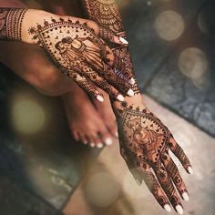 a woman's hands with hennap on it and some lights in the background