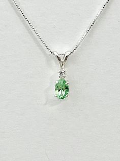 Light oval green cubic zirconia measures 6x4mm (1/2 carat). Tiny white accent cubic zirconia. Both stones were handset in sterling silver. Sterling silver box chain is 18 inches long and can be switched to a 16 inch chain upon request. Necklace is perfect for a child or the minimalist. Comes in a gift box Green Solitaire Necklace For May Birthstone Gift, Green May Birthstone Necklace For Anniversary, Green Cubic Zirconia Emerald Necklace In Fine Jewelry Style, May Birthstone Necklace In Cubic Zirconia, Green Cubic Zirconia Emerald Necklace Birthstone, Green Cubic Zirconia Emerald Necklace, Elegant Green Birthstone Necklace In Sterling Silver, Lime Green Necklace For May Birthstone Gift, Green Emerald Gemstone Necklace In Cubic Zirconia