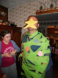 a man in a green costume standing next to a woman with a star on his head