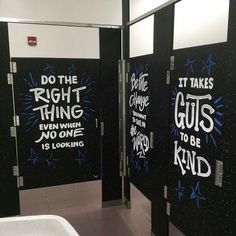 some black and white bathroom stalls with graffiti on them