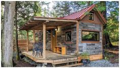 a small wooden cabin in the woods with a table and chairs on the front porch