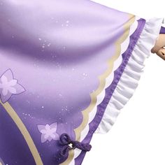 a purple and white dress with flowers on the skirt is being held by a doll