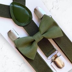 Olive Green Bow Tie & Olive Suspenders- The Perfect Wedding Look! Our olive bow tie & suspenders is a great choice for family photos, wedding, ring bearer outfit, birthday celebration or any other special occasion.  **Please Specify Above**  SET- Bow Tie and Suspenders SUSPENDERS- One Pair of our Quality Suspenders BOW TIE- One Bow Tie on white elastic strap or alligator clip Small: 9 months- 4 years *Bow Tie: 3.5in wide *Suspenders: Elastic, Y Back, 16in- 27in Medium: 5 years- 12 years *Bow Tie Classic Wedding Belts And Suspenders With Bow Tie, Dapper Suspenders For Wedding, Bow Tie And Suspenders Set For Father's Day Party, Dapper Wedding Suspenders, Classic Adjustable Bow For Groom, Adjustable Bow Tie Back Belt For Wedding, Adjustable Wedding Belt With Bow Tie Back, Dapper Adjustable Bow Tie For Weddings, Adjustable Bow Tie For Groom